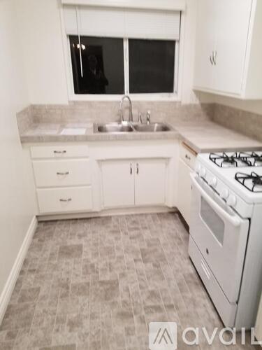 A kitchen with a white stove and sink.