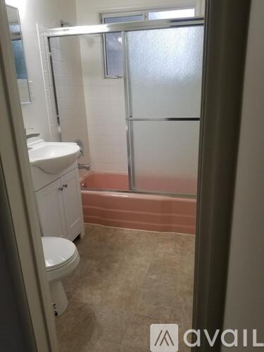 A bathroom with a toilet, sink, and shower.