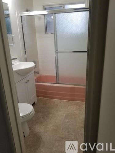 A bathroom with a toilet, sink, and shower.