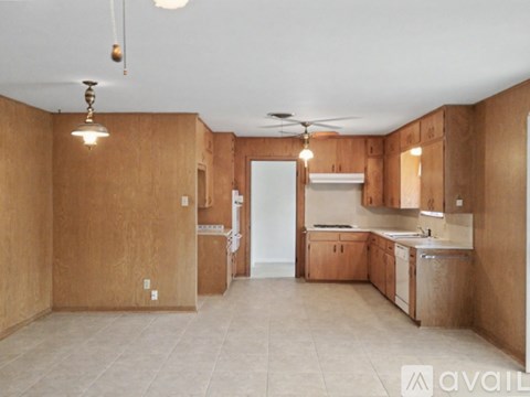 A kitchen with wooden cabinets and a white fridge is available.