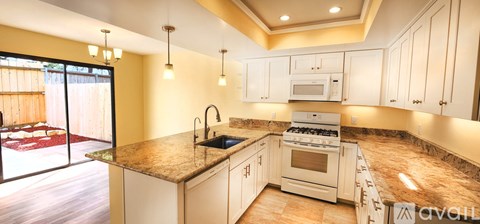 A kitchen with granite countertops and white cabinets.