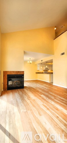 A living room with a fireplace and wooden floors.