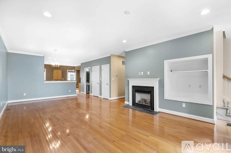A spacious living room with a fireplace and hardwood floors.