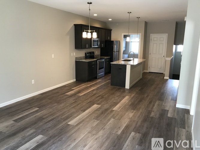 A kitchen with dark wood cabinets and a white island.