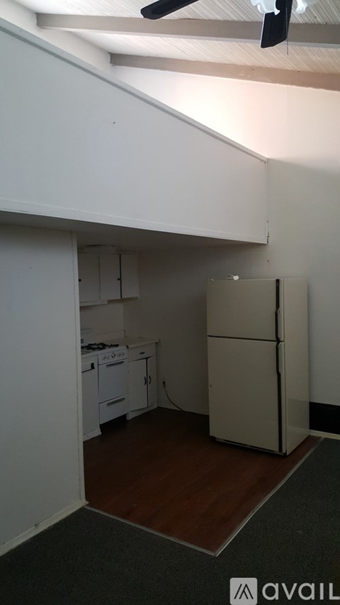 A kitchen with white cabinets and a white fridge.