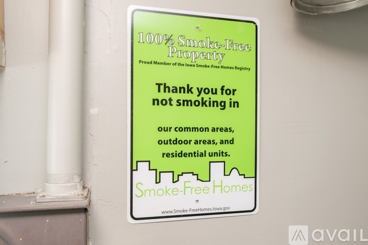 A sign on a wall that says "100% Smoke-Free Property".