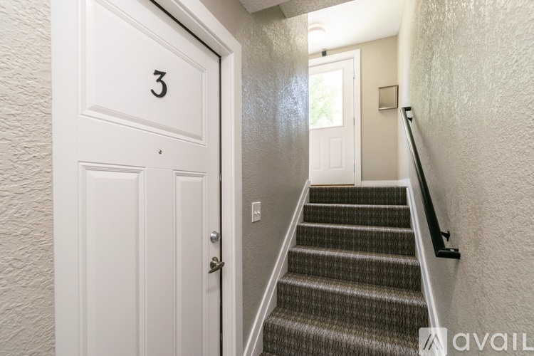A hallway with a staircase leading to a door with the number 3 on it.