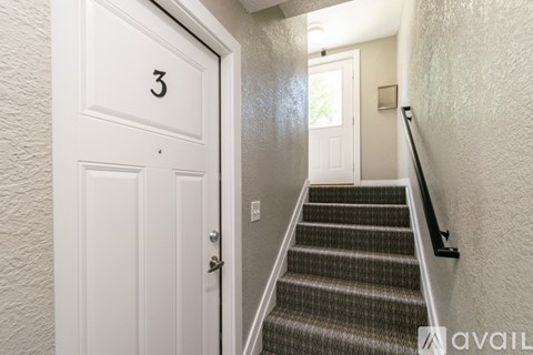A hallway with a staircase leading to a door with the number 3 on it.