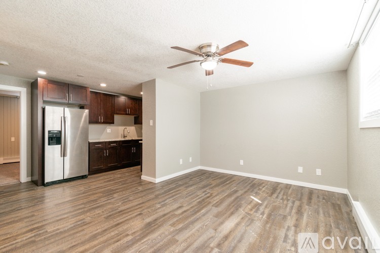 A spacious room with a ceiling fan and wooden flooring.