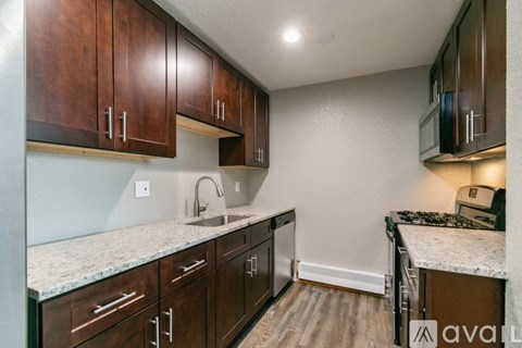 A kitchen with wooden cabinets and a granite countertop.