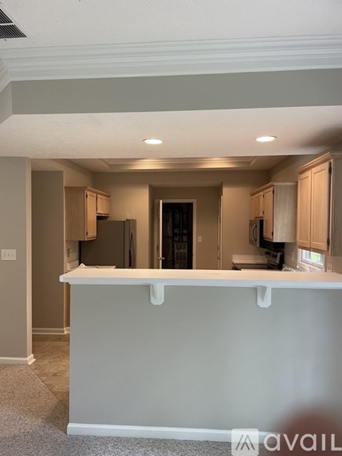 A kitchen with a white countertop and cabinets.