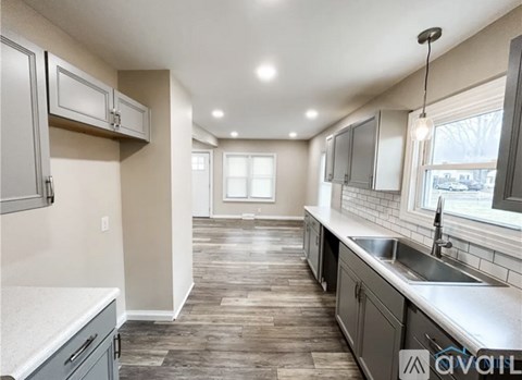 A kitchen with wooden floors and grey cabinets is available.