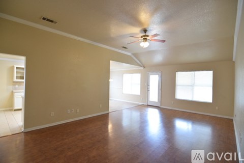 A spacious room with a ceiling fan and large windows.