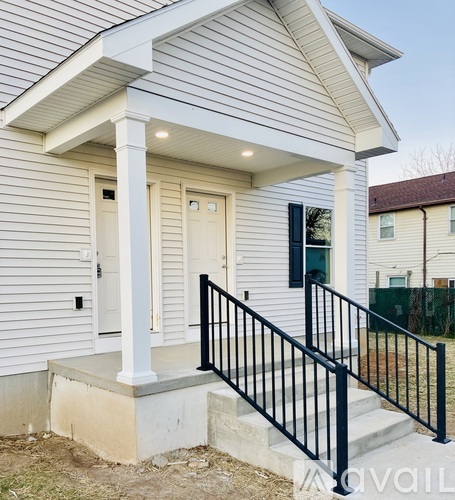 A house with a white front door and black railings.