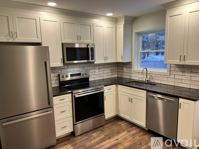 A kitchen with white cabinets and stainless steel appliances.