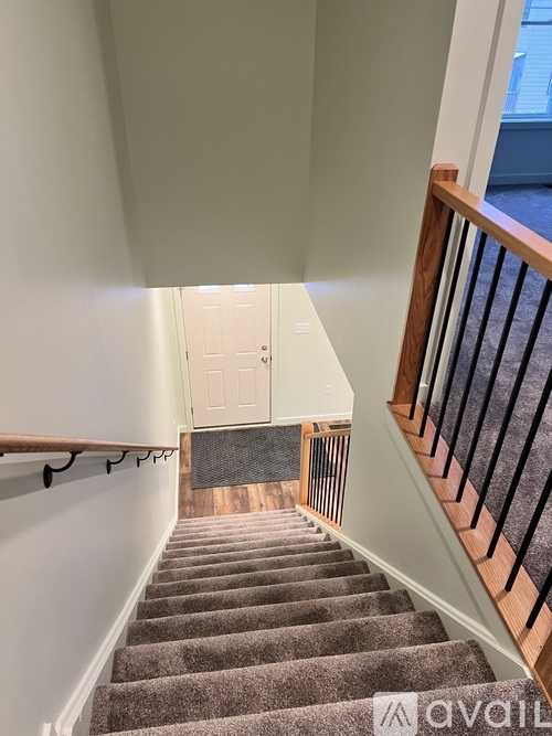 A staircase with a carpeted runner and wooden handrails.