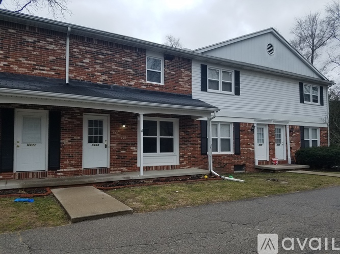 A two-story house with a brick facade and a white siding second story.