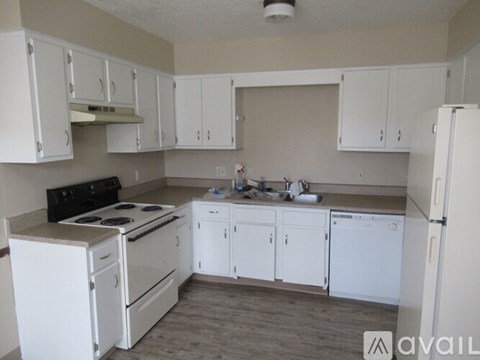 A kitchen with white appliances and cabinets.