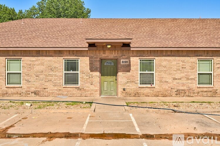 A brick building with a green door and windows.
