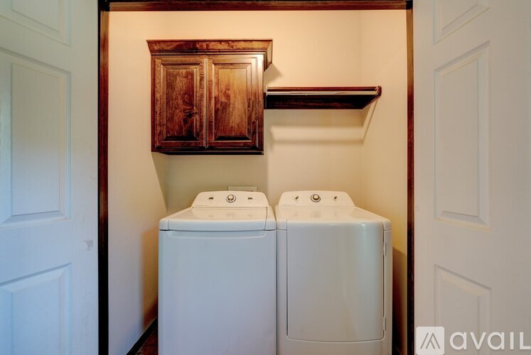 A white washing machine and dryer in a small laundry room.