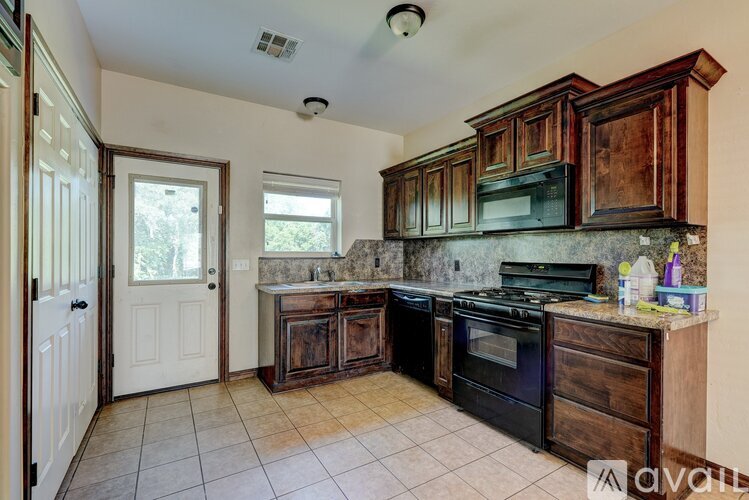 A kitchen with wooden cabinets and a black stove top oven.