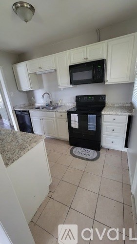 A kitchen with white cabinets and a black stove top oven.