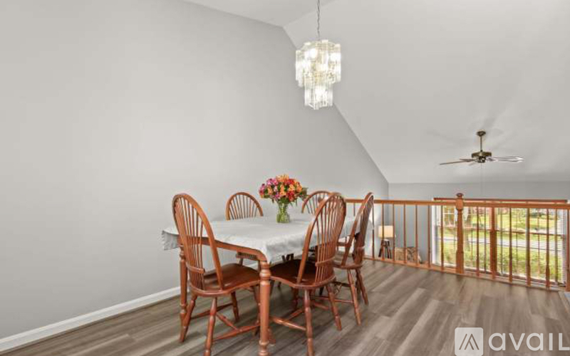 A dining room with a white table and chairs.