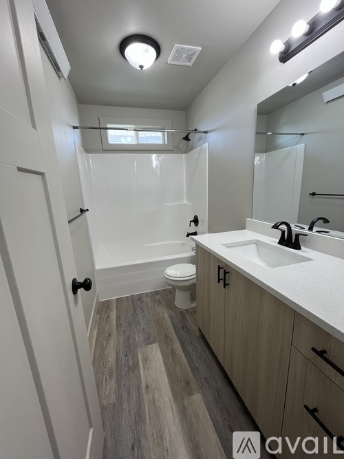 A bathroom with a toilet, sink, and mirror.