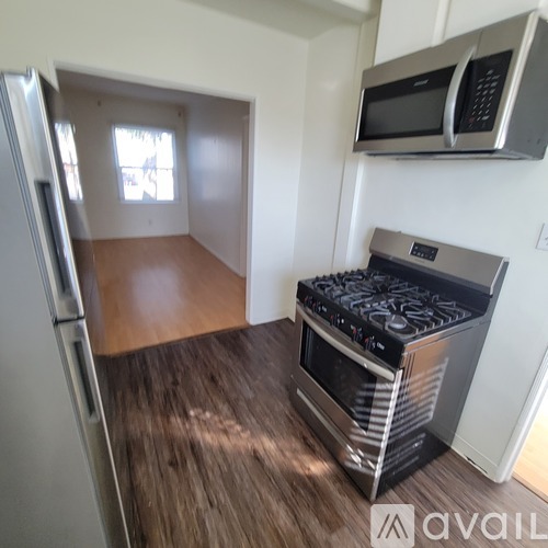 A kitchen with a stove and a microwave mounted on the wall.