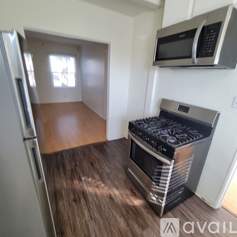 A kitchen with a stove and a microwave mounted on the wall.