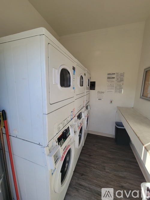 A row of washing machines in a small laundry room.