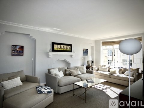 A living room with a grey couch and a glass coffee table.
