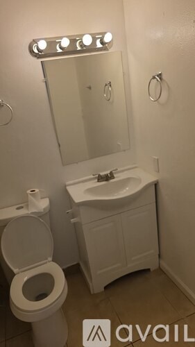A white toilet and sink in a small bathroom.