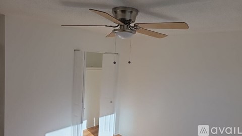 A ceiling fan with a light hanging from the ceiling in a room.
