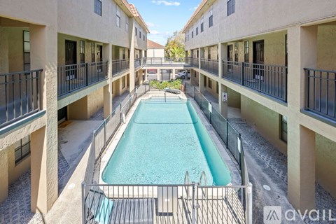 A pool in a courtyard surrounded by buildings.