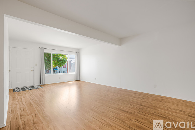 A room with wooden flooring and white walls.