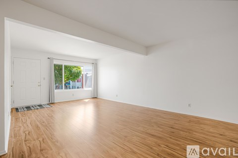 A room with wooden flooring and white walls.