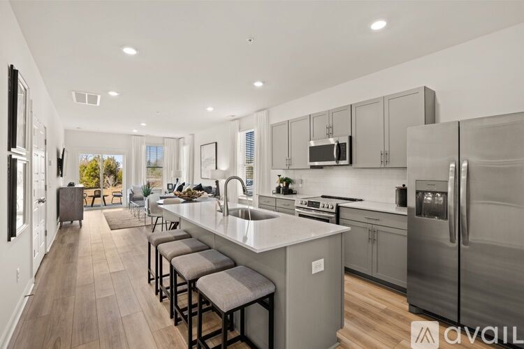A modern kitchen with a large island and stainless steel appliances.