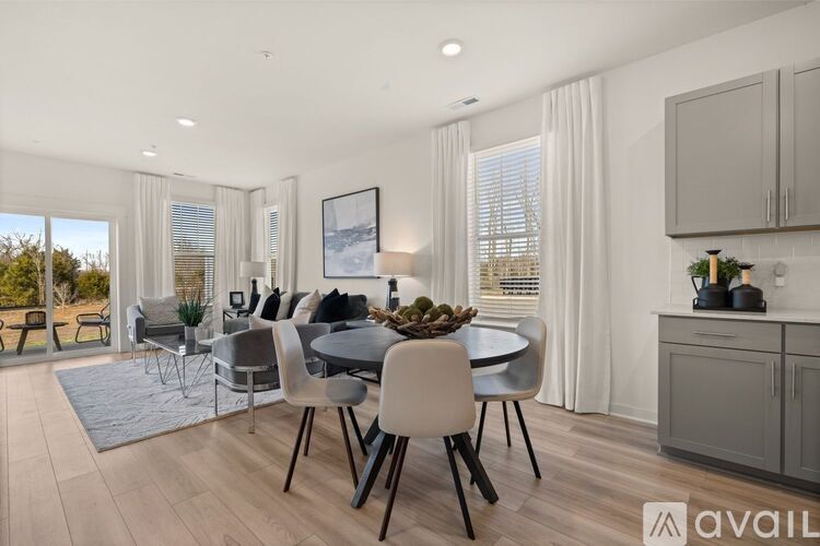 A modern dining room with a table set for six and a view of the outdoors.
