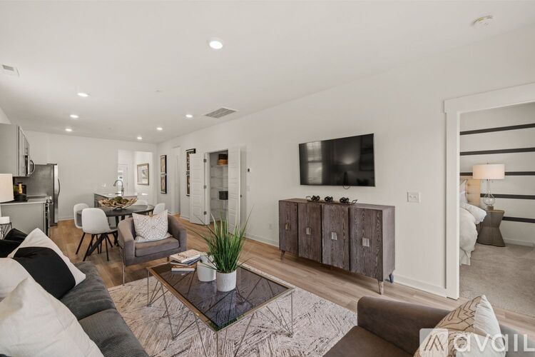 A modern living room with a grey sofa, a coffee table, and a television.