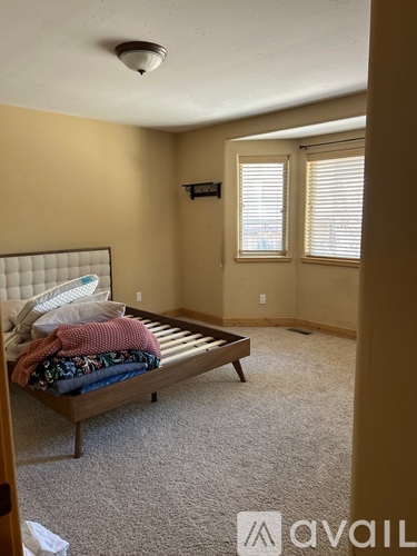 A bedroom with a bed and a window.