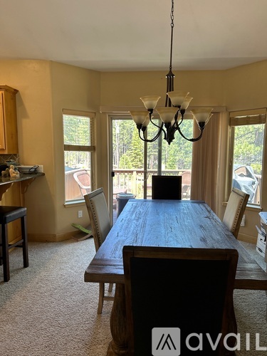A dining room with a wooden table and chairs.
