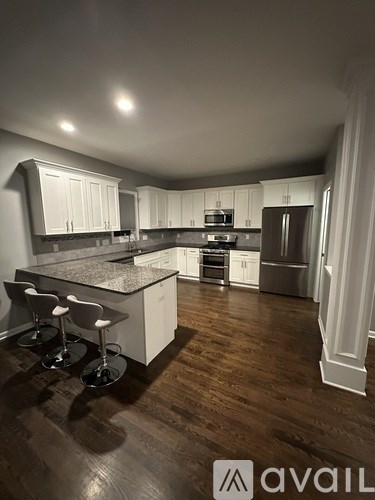 A kitchen with white cabinets and a granite countertop.