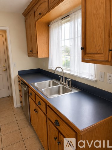 A kitchen with wooden cabinets and a black countertop.