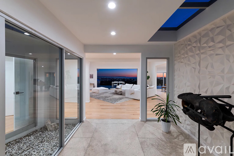 A modern interior space with a glass door leading to a balcony.