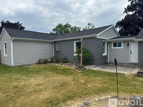 A grey house with a white door and windows.