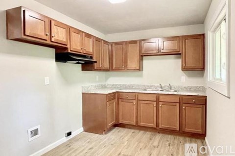 A kitchen with wooden cabinets and a marble countertop.