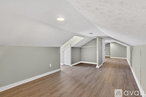 A room with wooden flooring and a ceiling with exposed beams.