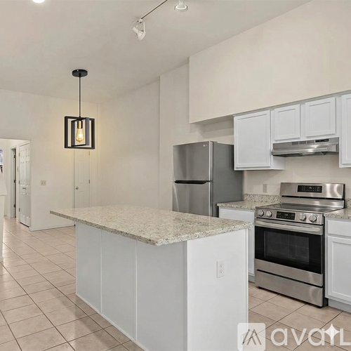 A kitchen with white cabinets and a granite countertop.