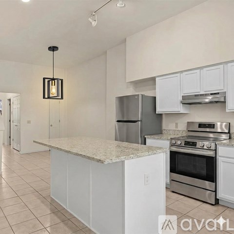 A kitchen with white cabinets and a granite countertop.